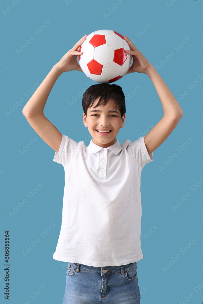 Little boy with soccer ball on blue background