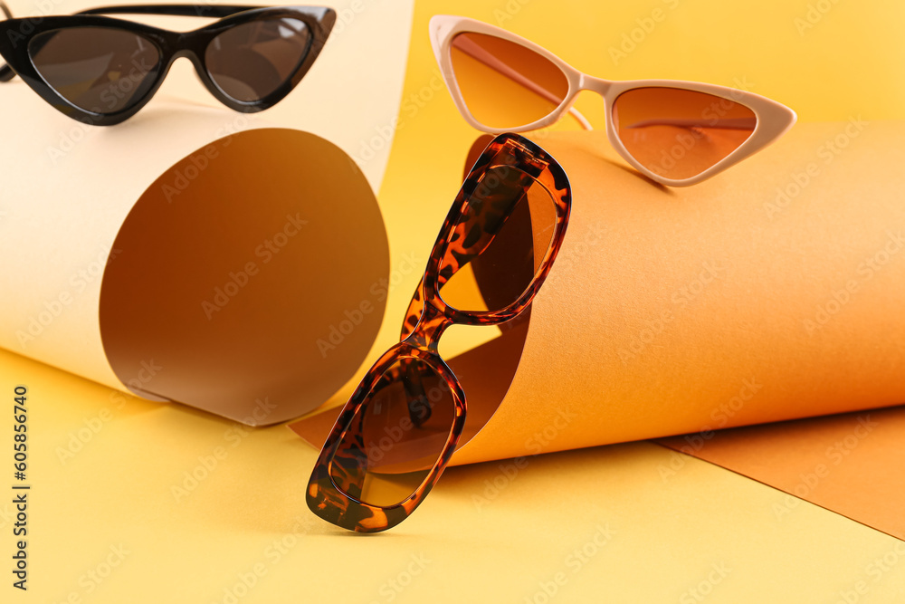 Stylish sunglasses on color background