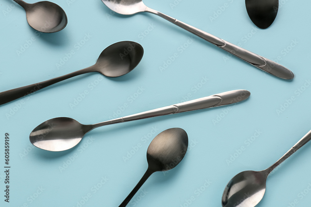 Stainless steel spoons on blue background