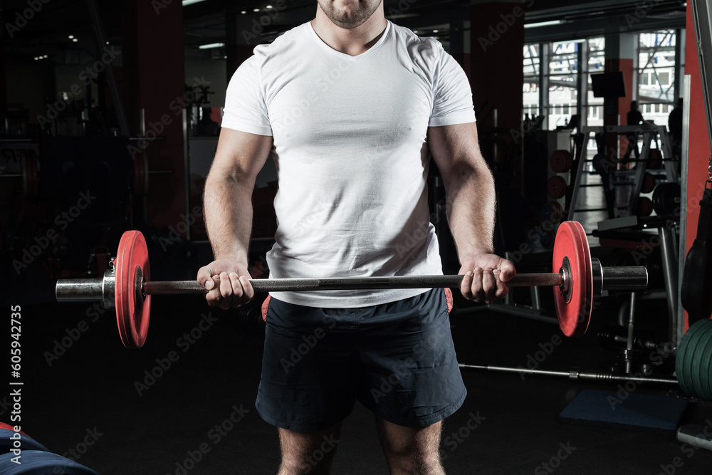 Male athlete lifts the barbell