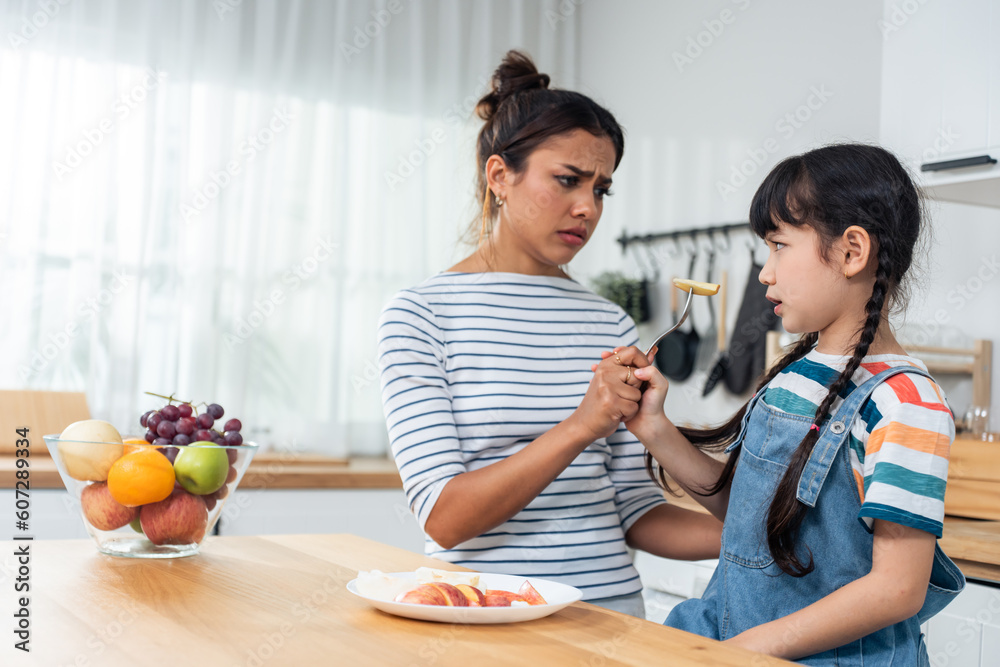 Asian mother teaching and motivate young girl child eat healthy fruit. 