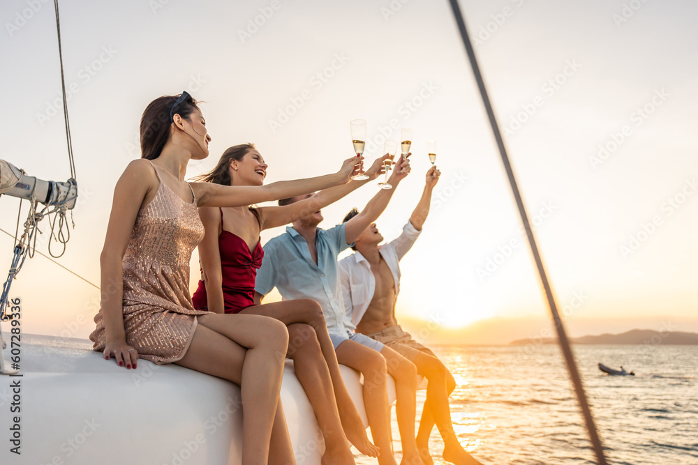 Group of diverse friends drink champagne while having a party in yacht. 