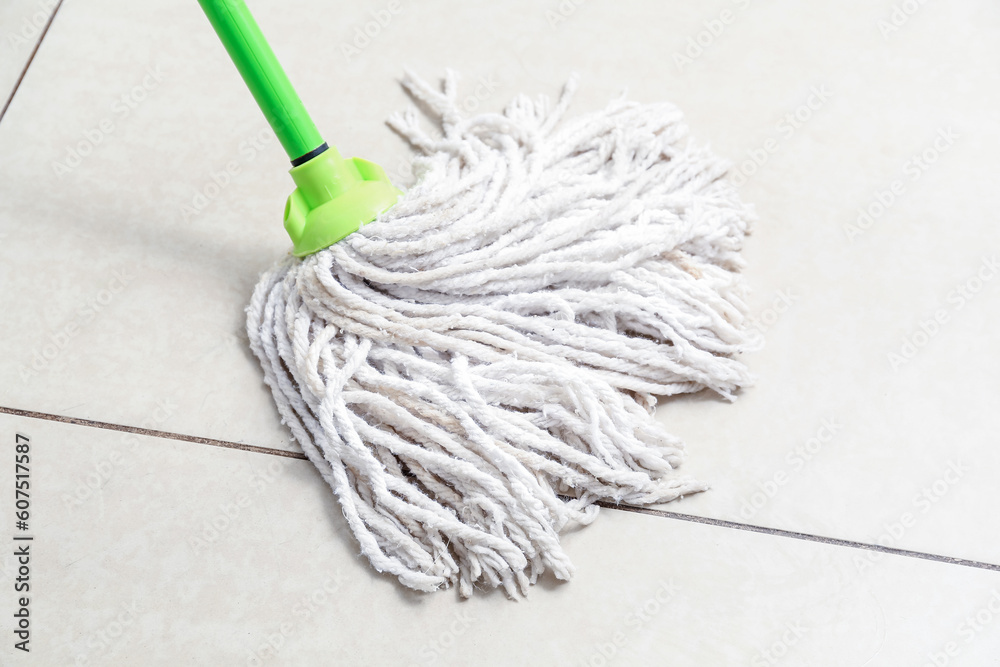 Mop on light tile floor, closeup