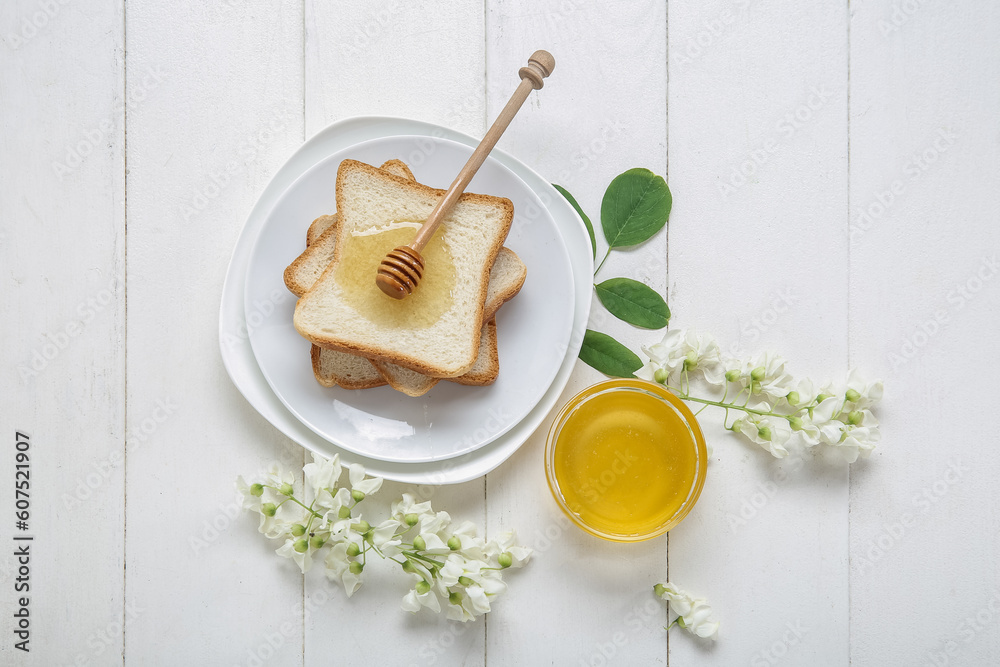 Composition with sweet honey, acacia flowers and toasts on light wooden background