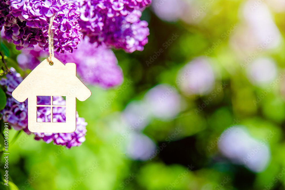 The symbol of the house among the branches of the pink lilac