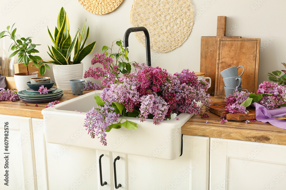 Blooming lilac twigs in kitchen sink