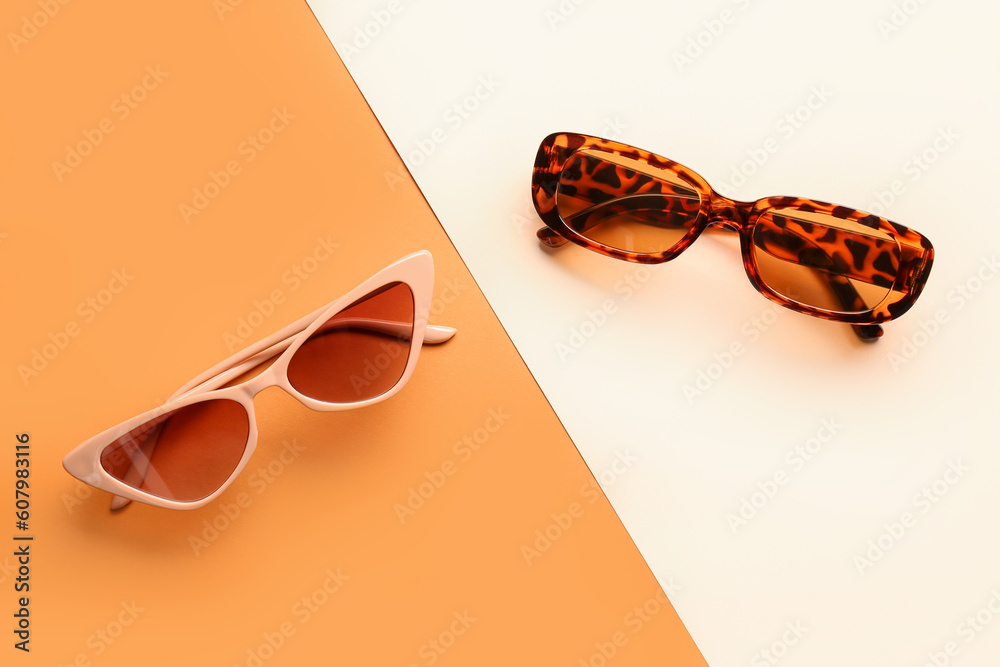 Stylish sunglasses on color background