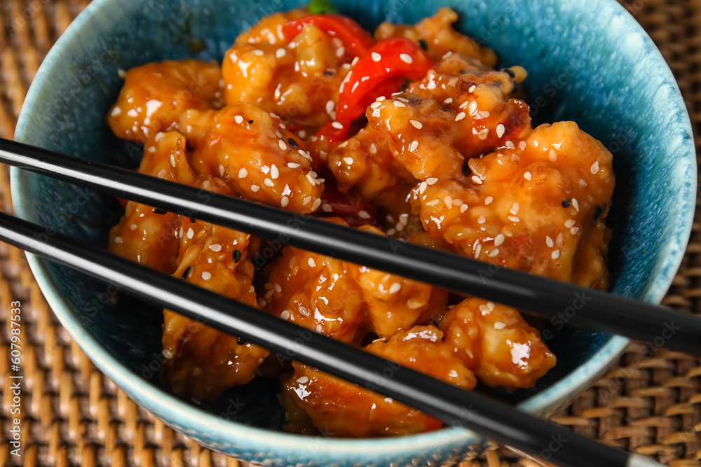 Bowl with tasty sweet and sour chicken on table, closeup