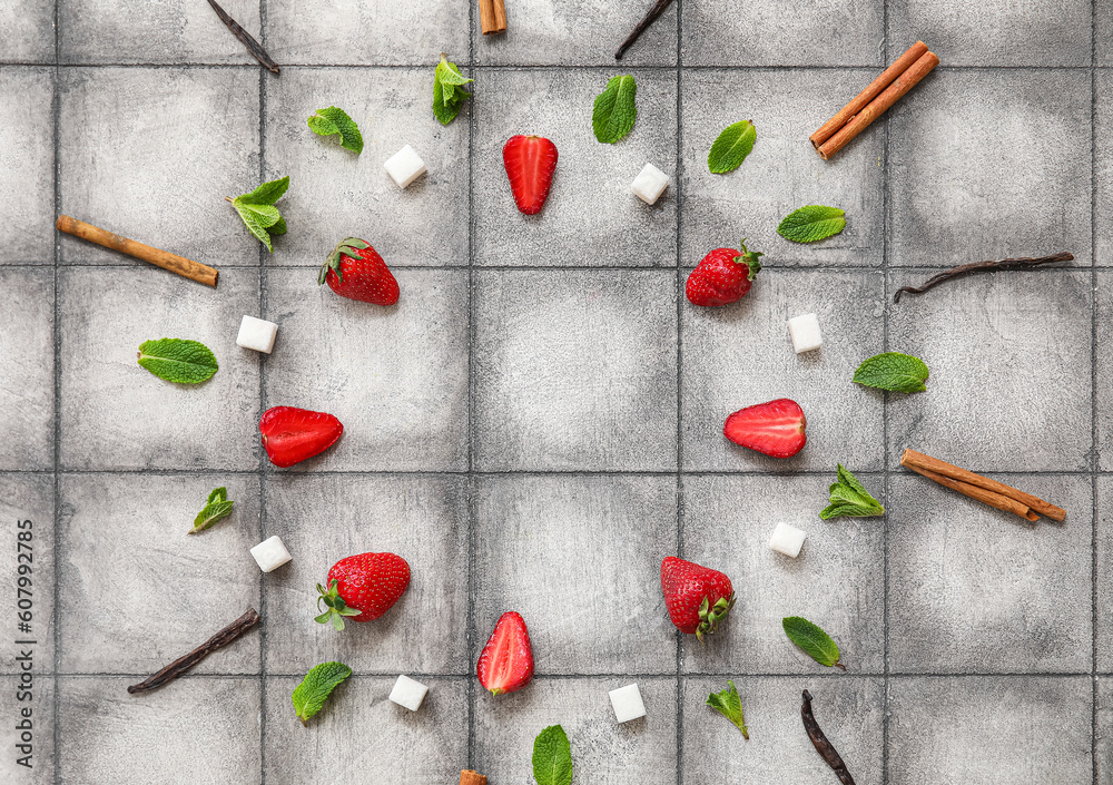 Frame made of ingredients for preparing strawberry compote on grey tile background