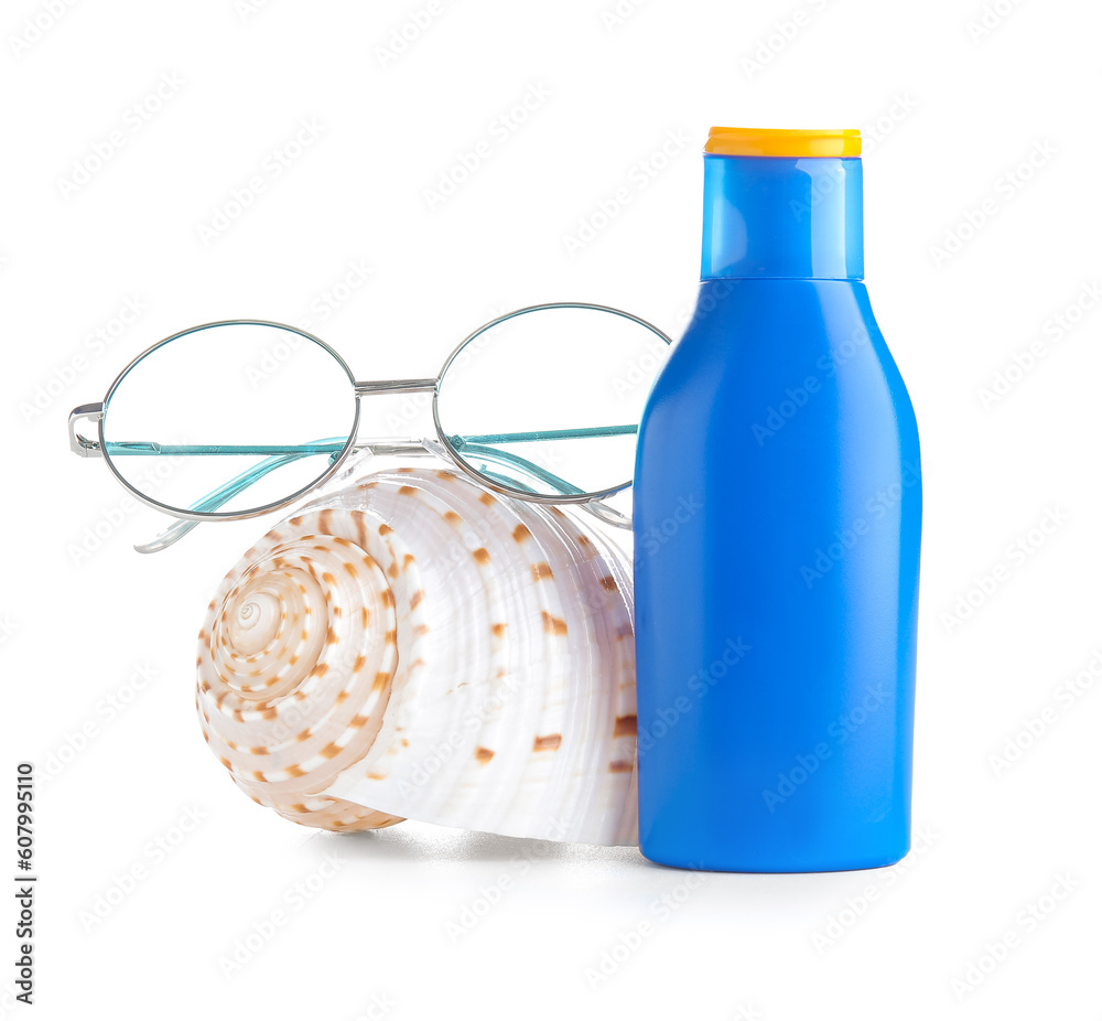 Bottle of sunscreen cream with sunglasses and seashell isolated on white background