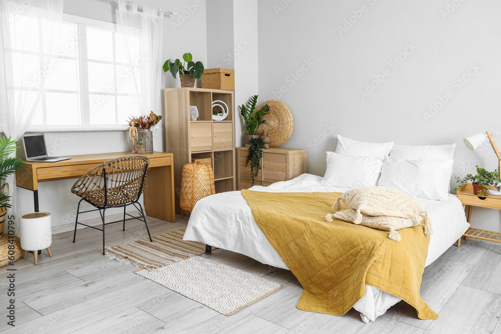 Interior of light bedroom with modern workplace