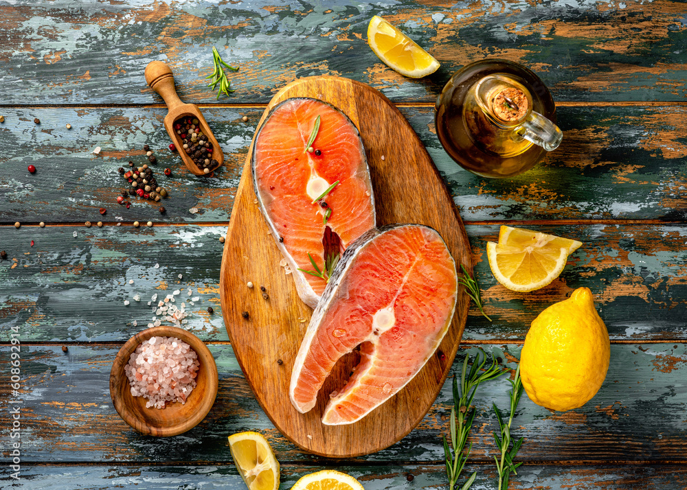 Two fresh fish salmon pieces. Raw Salmon steaks with lemons on wooden board.