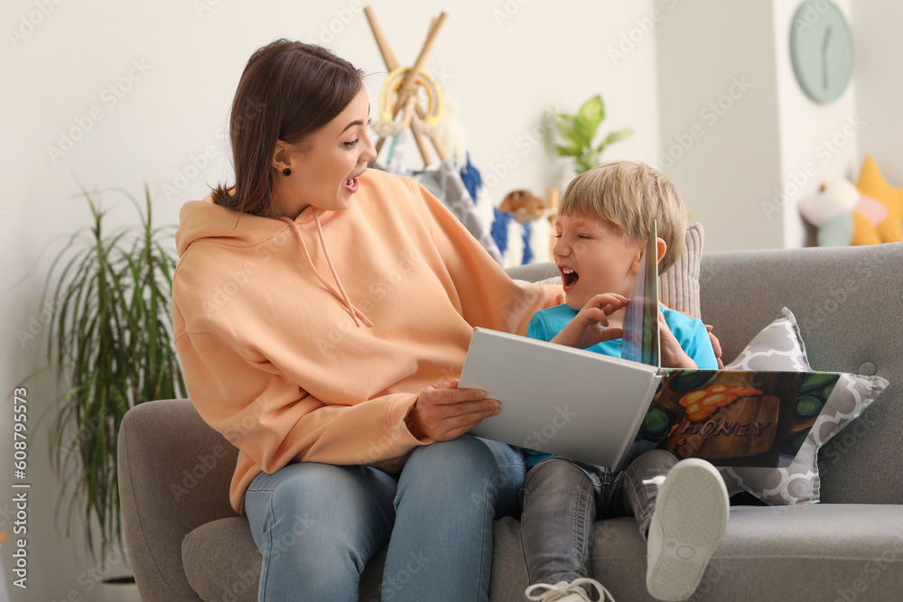 Nanny reading story to little boy at home