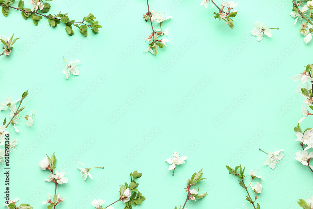 Frame made of blooming tree branches with white flowers on turquoise background