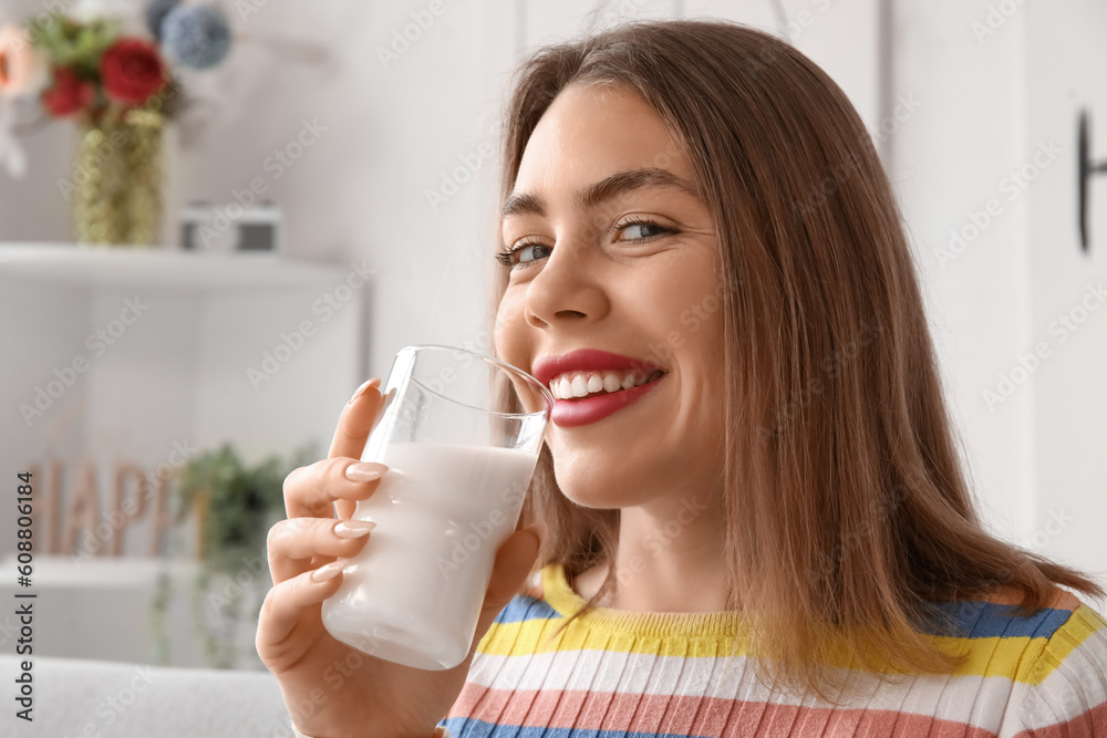 Young woman with glass of milk at home, closeup