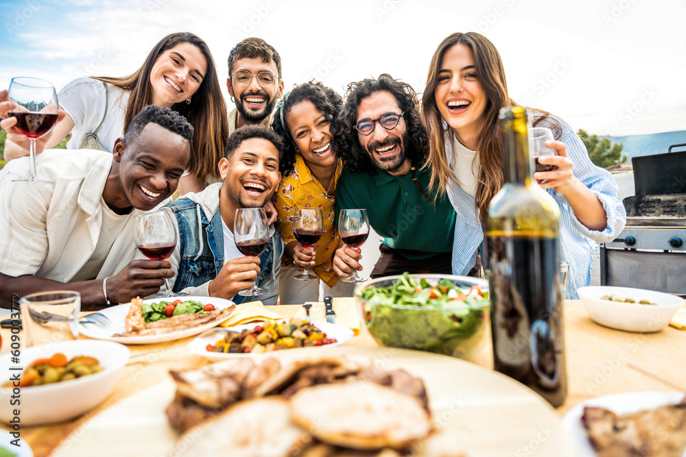 Group of young people having fun drinking red wine on balcony rooftop bbq dinner party - Happy multi