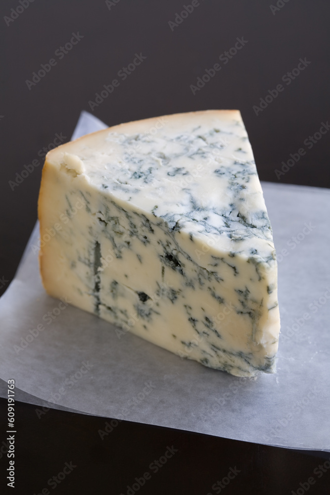 Aged Mountain blue cheese wedge on wax paper on a table