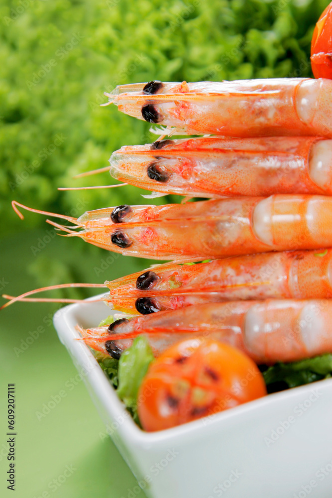 Prawns in white dish with bright green background