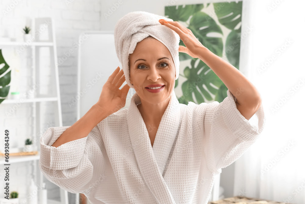 Mature woman with towel in bathroom