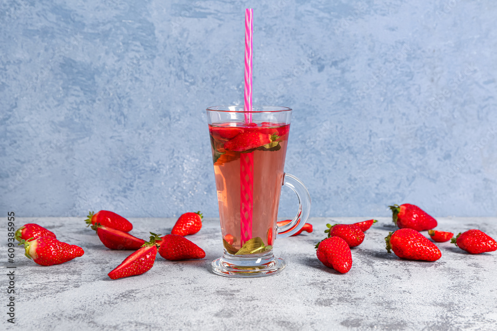 Glass of tasty strawberry juice on grey table