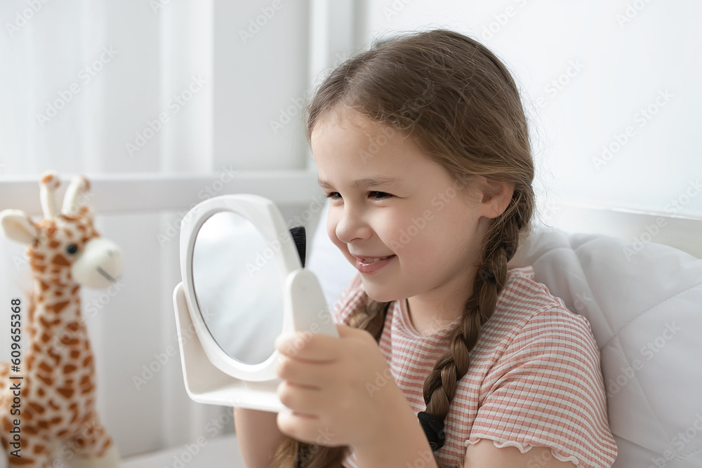 little girl applying makeup . A child applies makeup in front of a mirror