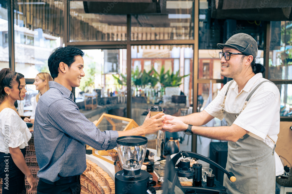 Asian attractive men receive hot coffee from waiter in coffee house. 