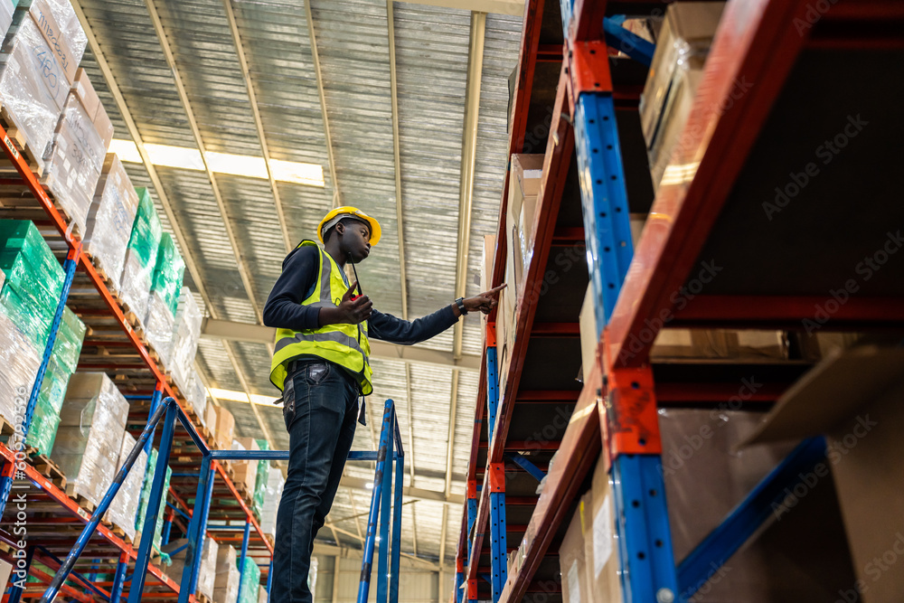 African American man industry worker working alone in factory warehouse. 