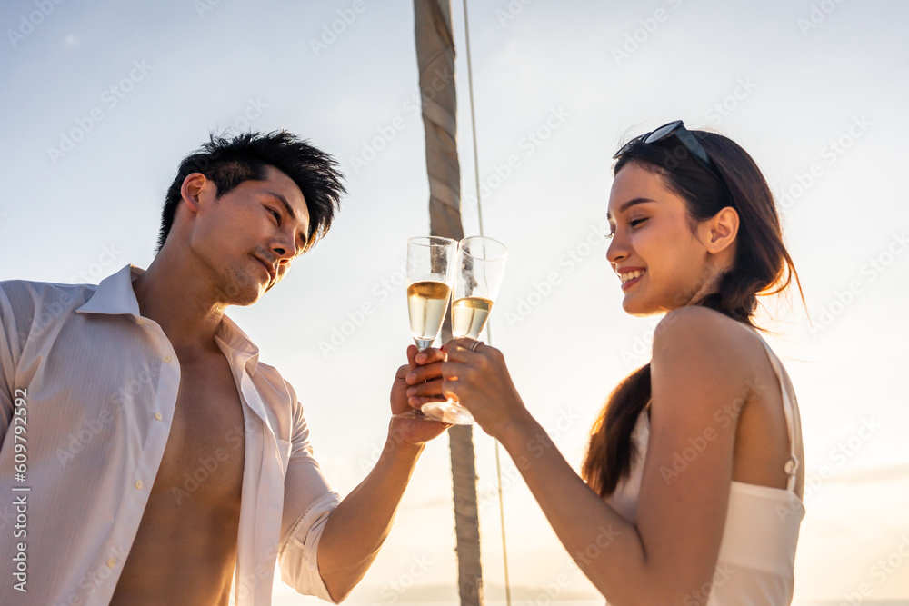 Asian beautiful couple drinking champagne while having party in yacht. 