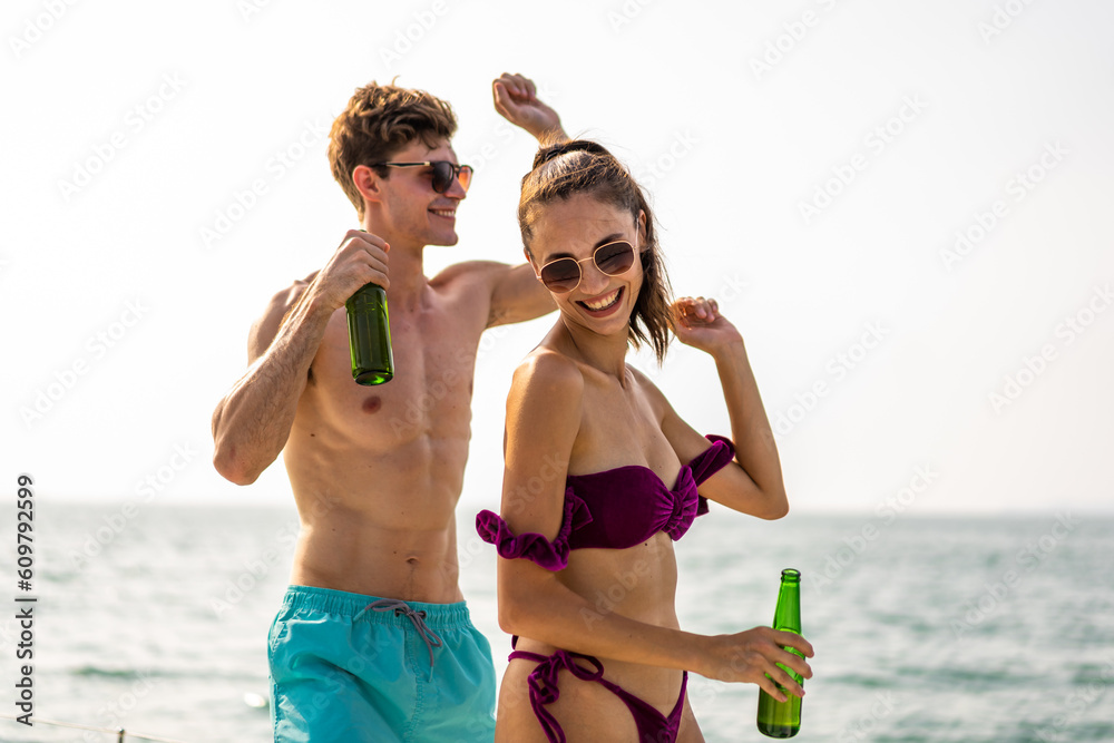 Caucasian young couple drink a bottle of beer, having party in yacht. 