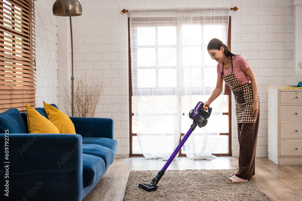 Asian young beautiful woman cleaning indoors in living room at home. 