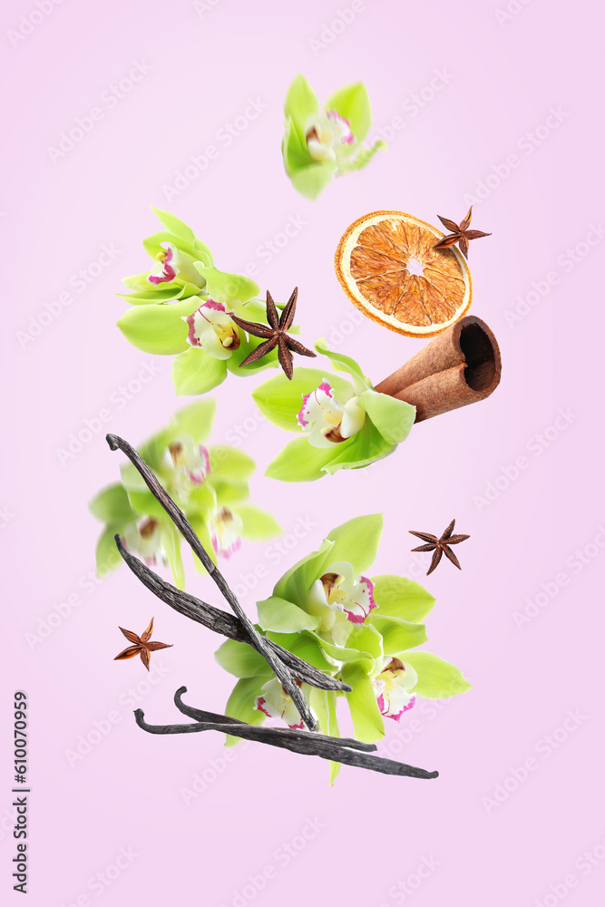 Flying vanilla sticks, orchid flowers and spices on pink background