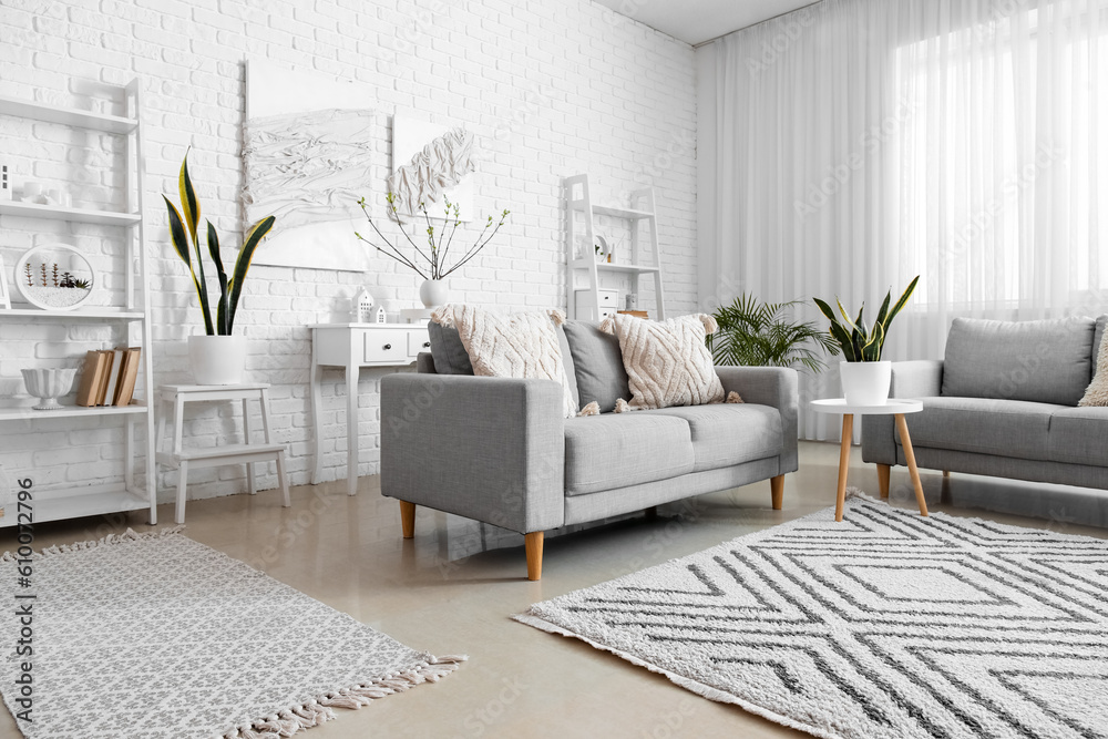 Stylish interior of light living room with posters on wall