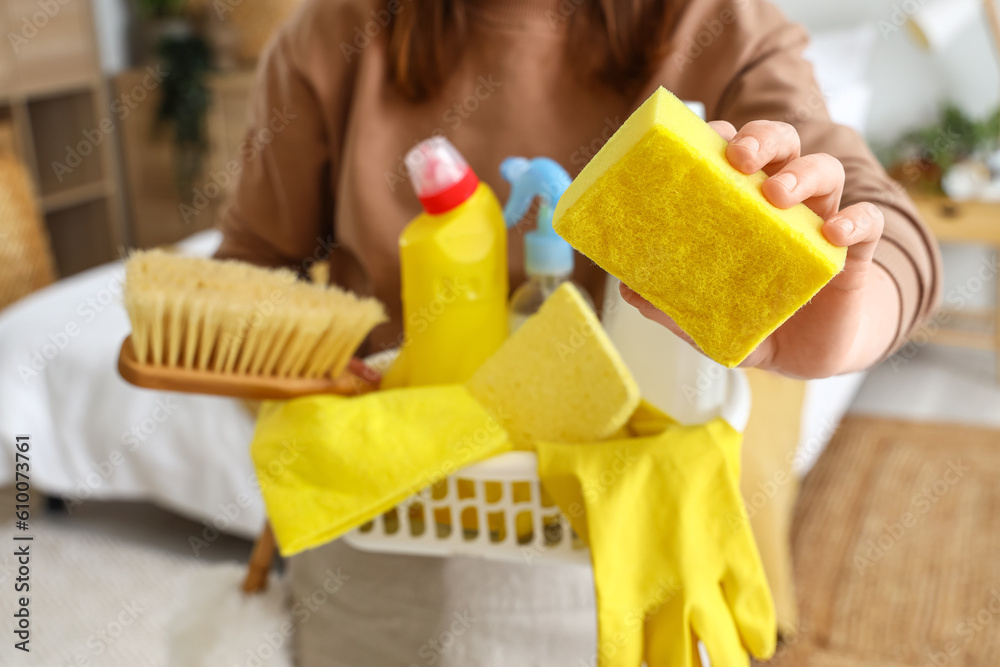 Housewife with cleaning supplies in bedroom, closeup