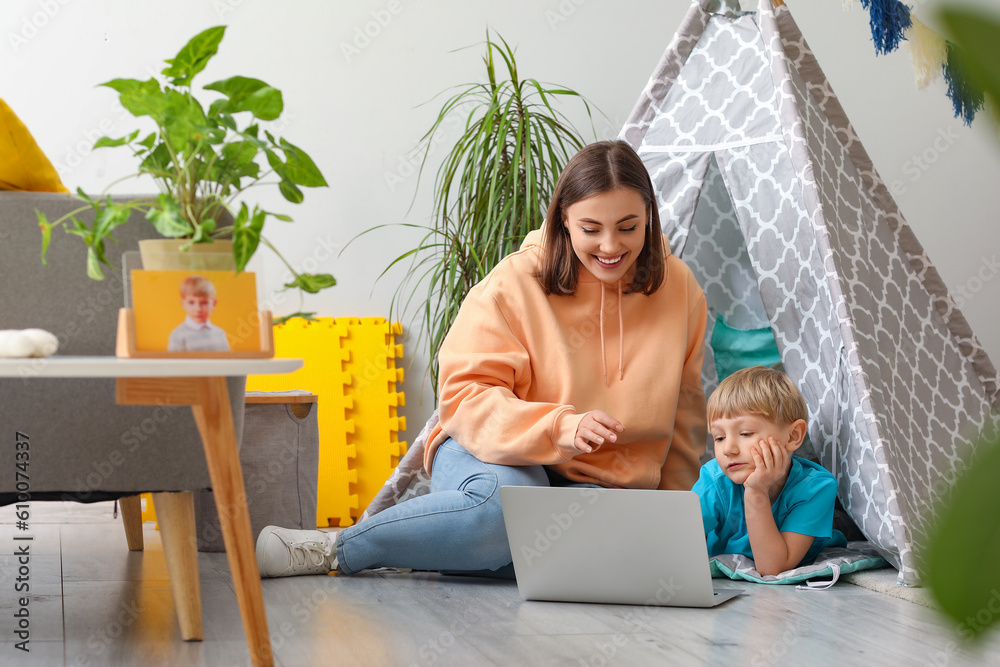 Nanny with little boy watching cartoons at home