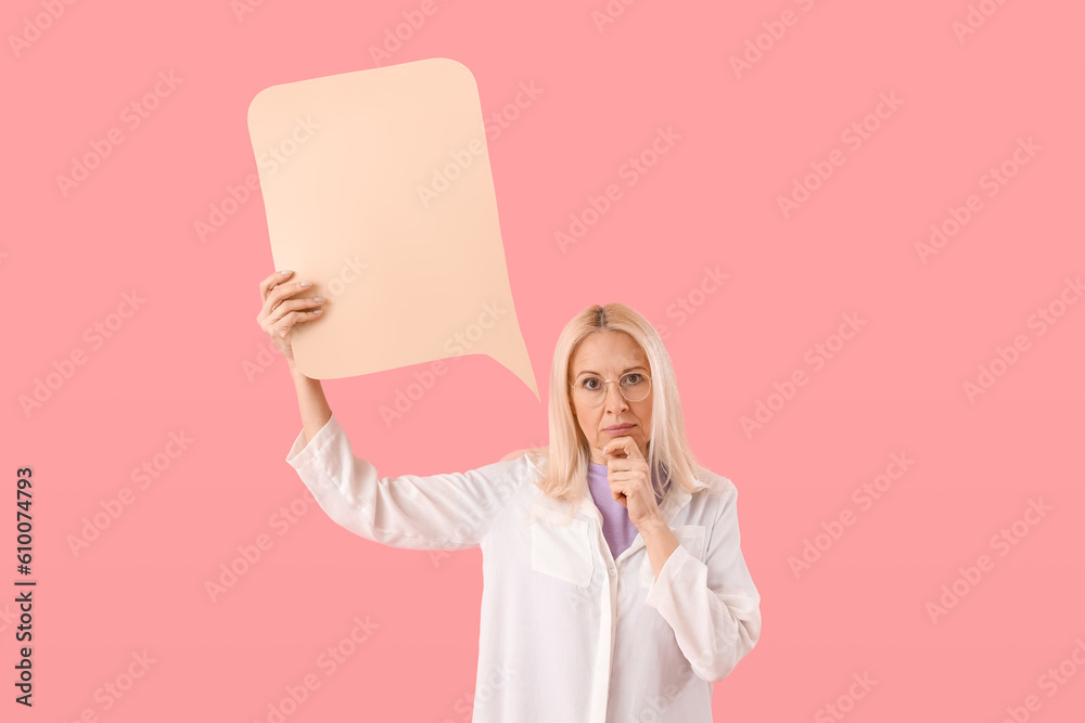 Thoughtful mature woman with blank speech bubble on pink background