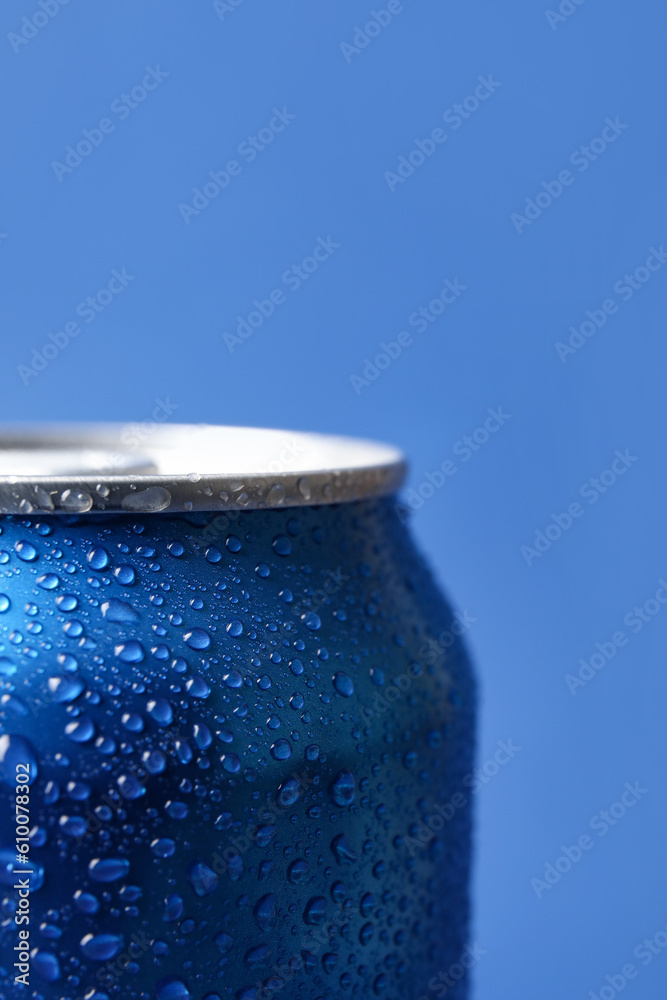 Can of fresh soda with water drops on blue background, closeup