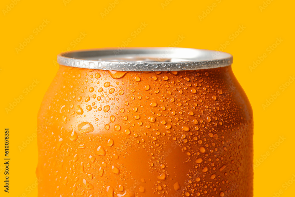 Can of fresh soda with water drops on orange background, closeup