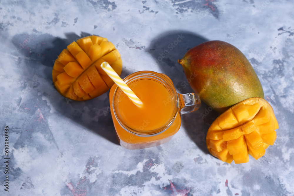 Mason jar of fresh mango smoothie on blue background