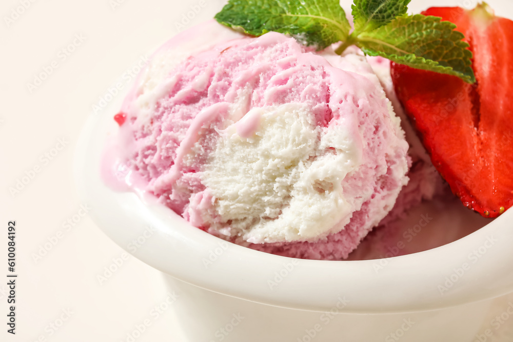 Bowl of strawberry ice cream with mint on white background, closeup