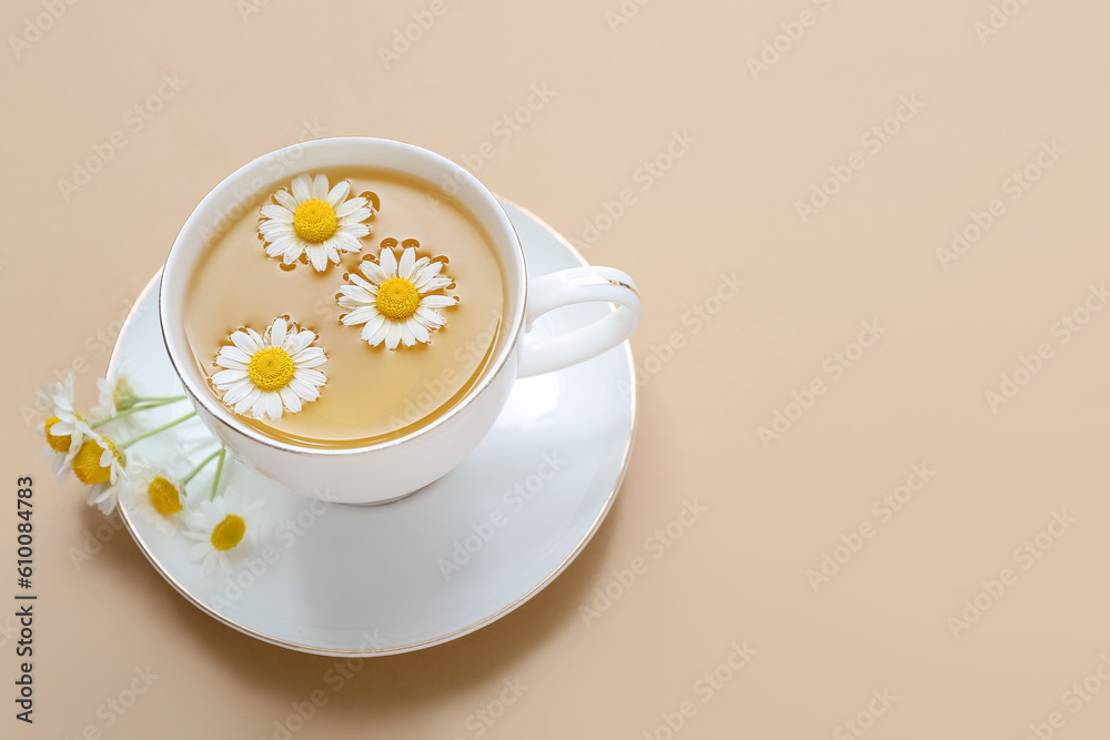 Cup of hot chamomile tea on beige background