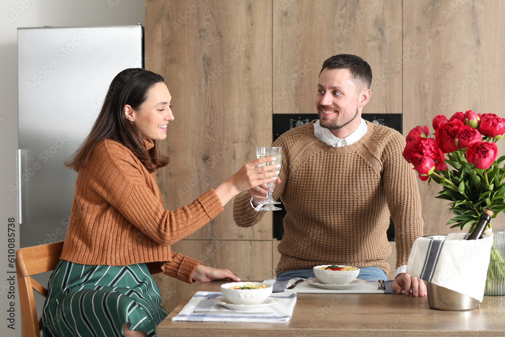 Young couple drinking on date in kitchen