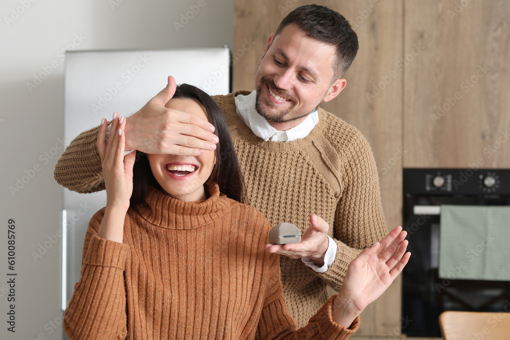 Young man proposing to his girlfriend in kitchen