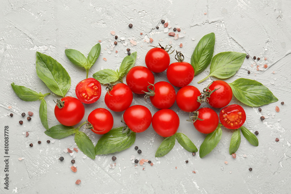 Composition with ripe cherry tomatoes, basil leaves and peppercorn on color background