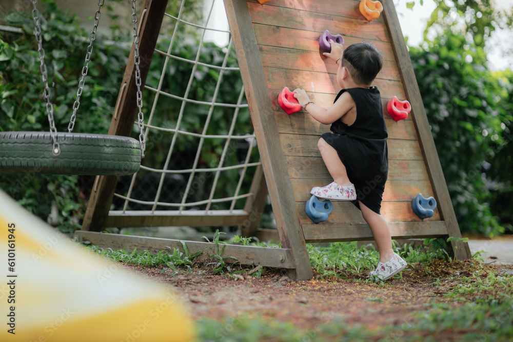 Asian little boy playing in the playground outdoor. Kids play on school or kindergarten yard. Health