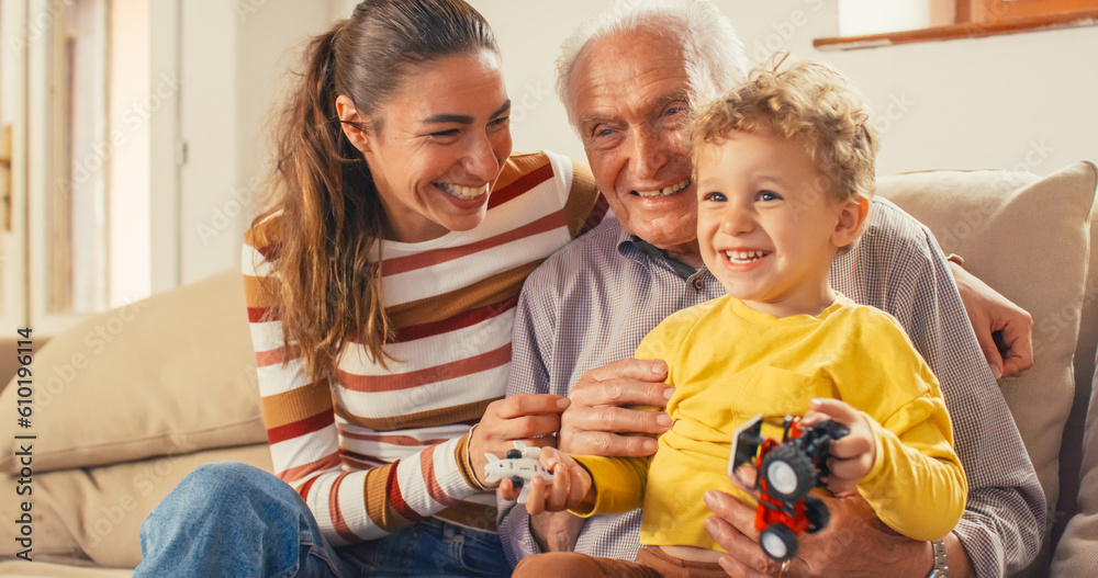 Portrait of a Small Family of a Mother, a Son and a Grandfather Watching TV Together in the Living R