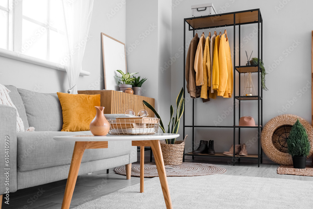 Interior of living room with shelving unit and clothes