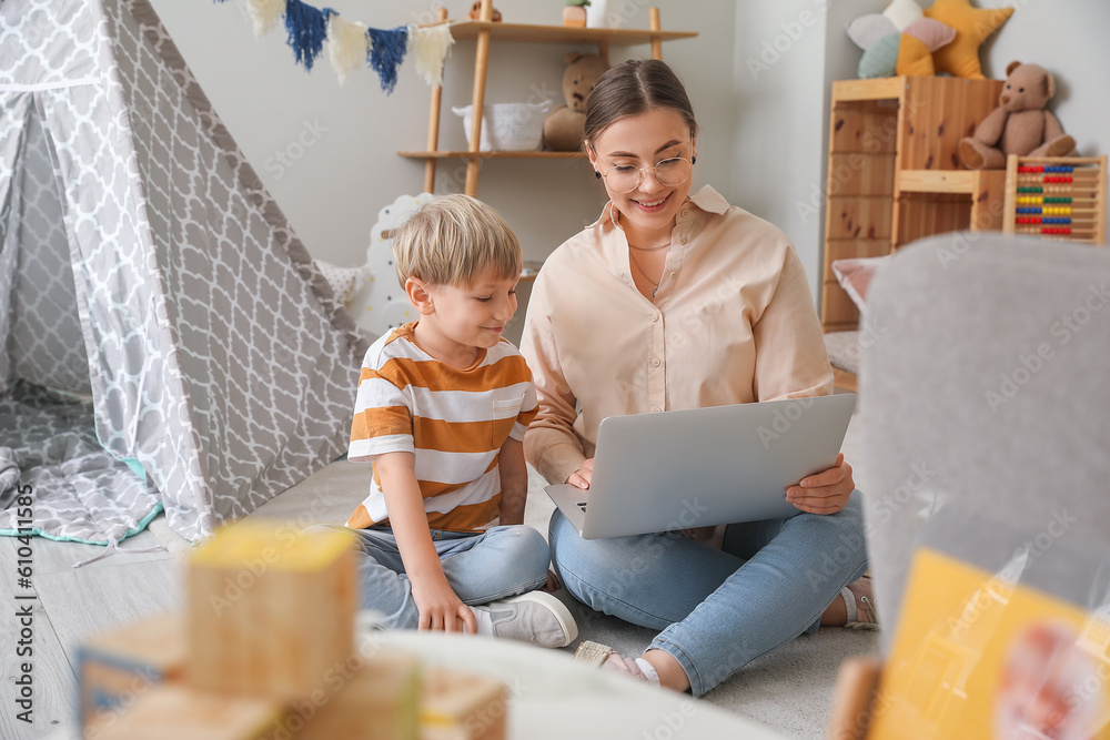 Nanny with little boy watching cartoons at home