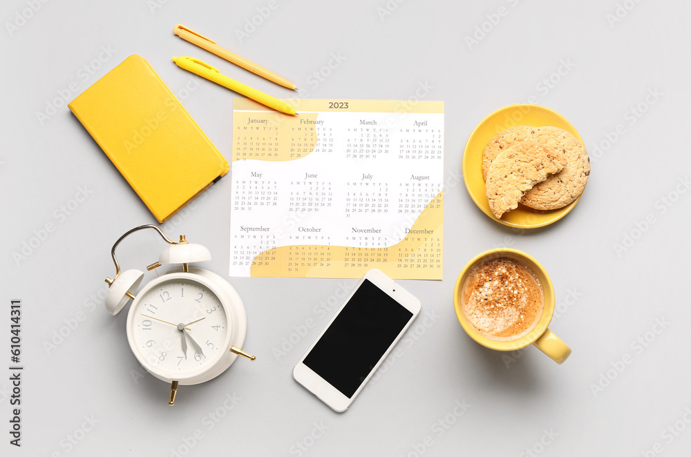 Composition with calendar, mobile phone, alarm clock, cup of coffee and cookies on grey background