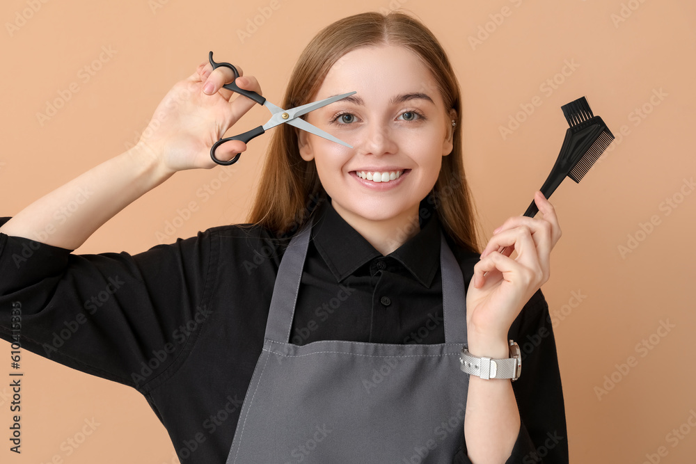 Female hairdresser with scissors and brush on beige background, closeup