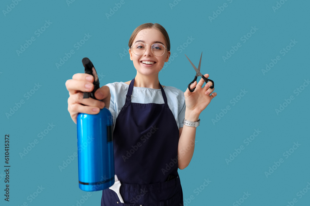 Female hairdresser with scissors and spray on blue background